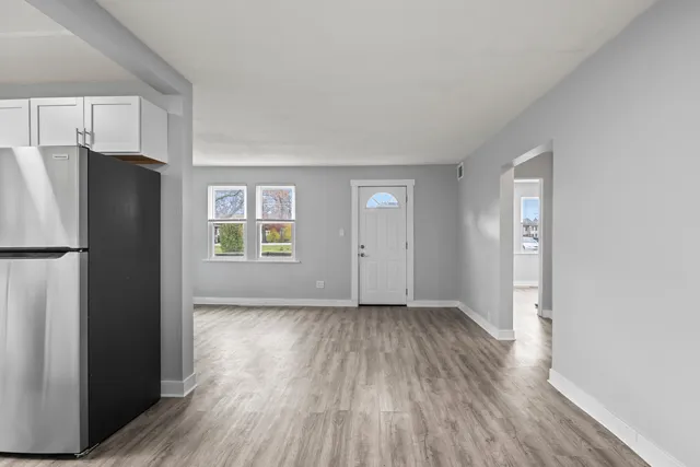 a view of an empty room with a window and wooden floor