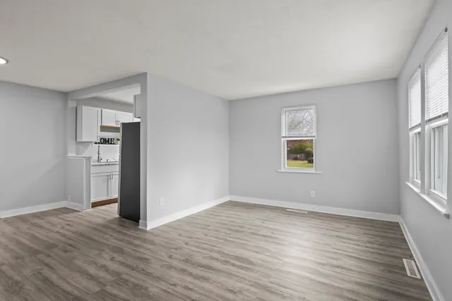 a view of empty room with wooden floor and window