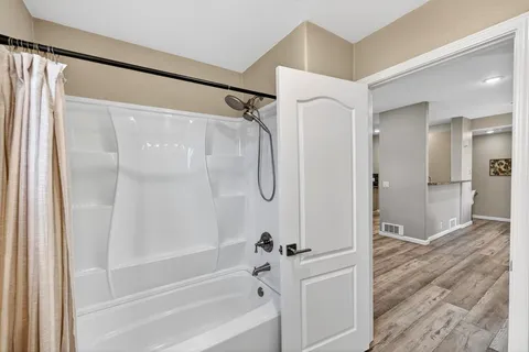 a bathroom with a glass shower door and a bathtub