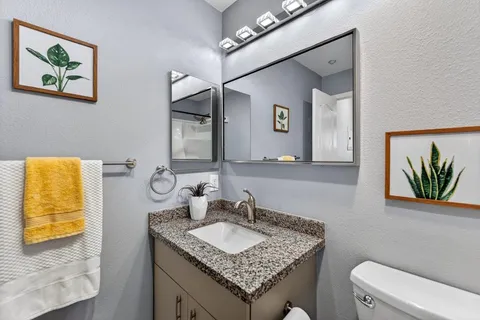 a bathroom with a granite countertop sink and a mirror