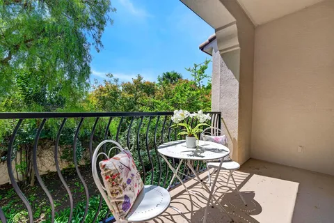 a balcony with furniture and potted plants