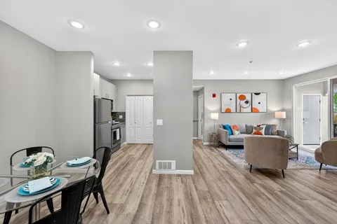a living room with furniture and a wooden floor