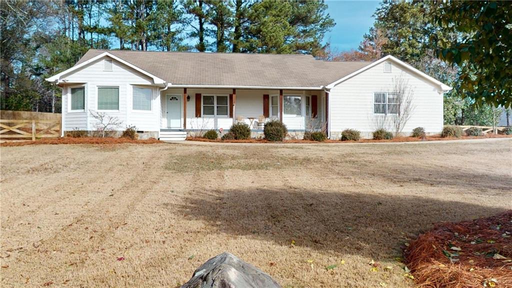 a view of a house with a yard and large tree