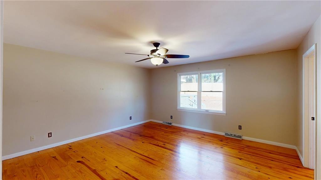 1042 Mission Road Southwest Cartersville, GA 30120 - Photo 18 of 40 an empty room with a window and a ceiling fan