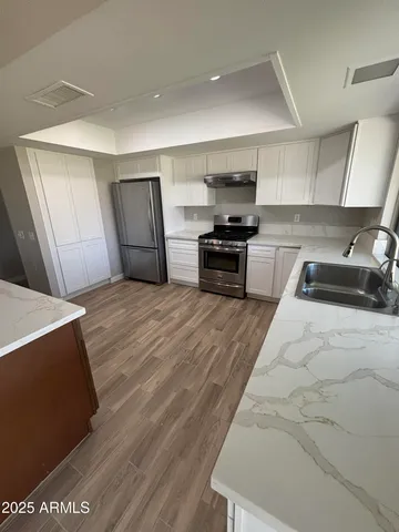 a kitchen with stainless steel appliances a stove a sink and a refrigerator