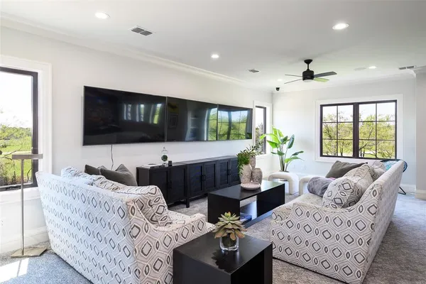 a living room with furniture a large window and a flat screen tv