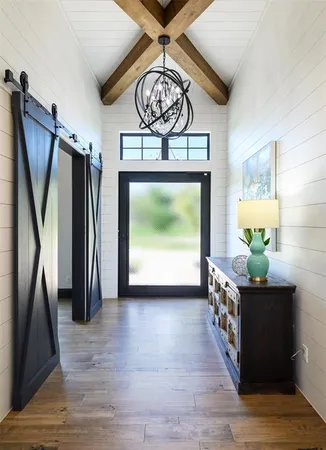 a view of a hallway with wooden floor and a chandelier