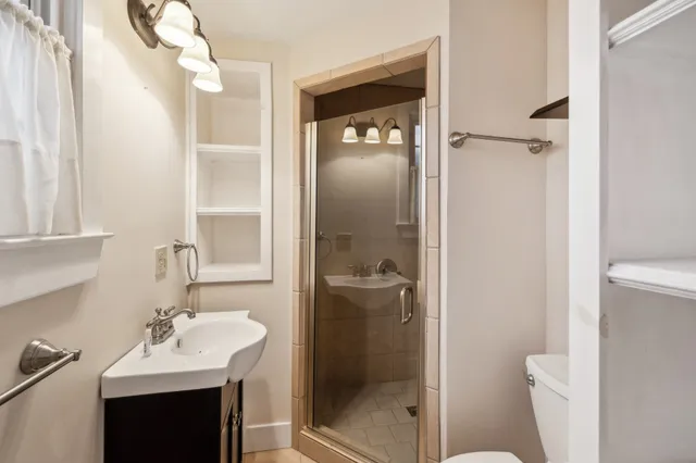 a bathroom with a sink vanity mirror and toilet