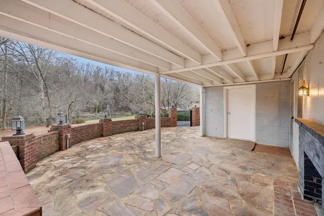 a view of an empty room with a fireplace and a window