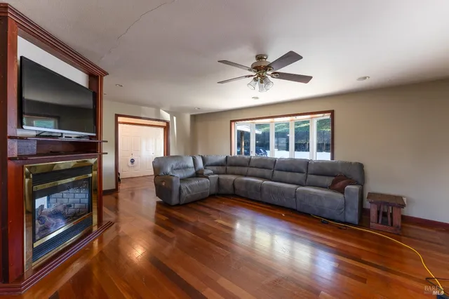 a view of a livingroom with furniture wooden floor and a ceiling fan