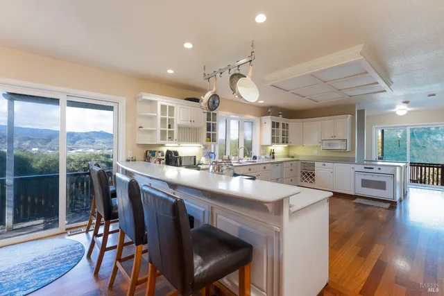 a kitchen with granite countertop white cabinets and white appliances