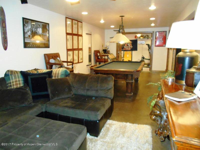 1501 Arabian Avenue Rifle, CO 81650 - Photo 15 of 23 a living room with furniture a table and a flat screen tv