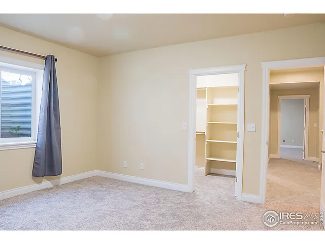an empty room with closet and windows