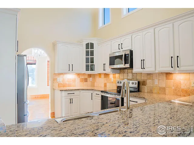 a kitchen with stainless steel appliances kitchen island granite countertop a sink and a microwave