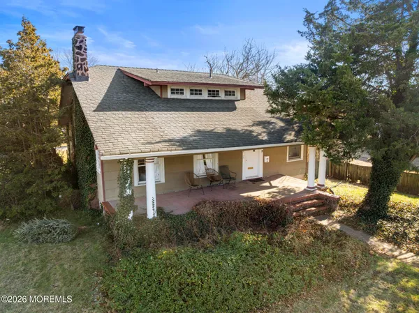 a view of a house with a yard and large tree