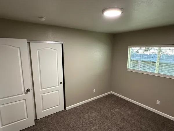 an empty room with windows and closet