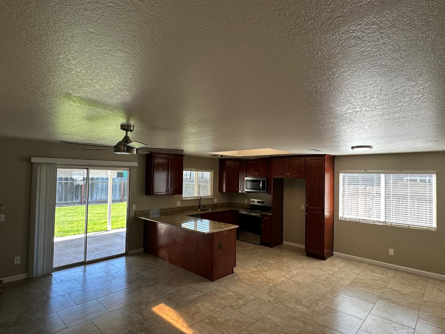 924 Kingery Drive Ripon, CA 95366 - Photo 2 of 18 a kitchen with kitchen island granite countertop a stove top oven a sink and a granite counter top