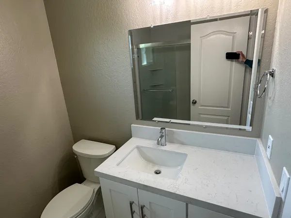 a bathroom with a sink a toilet and shower