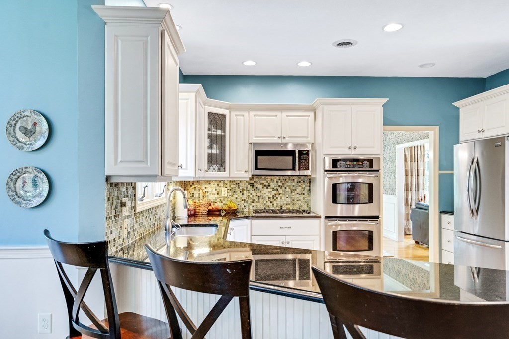 8 Liberty Road Medfield, MA 02052 - Photo 6 of 29 a kitchen with stainless steel appliances a dining table chairs and a refrigerator