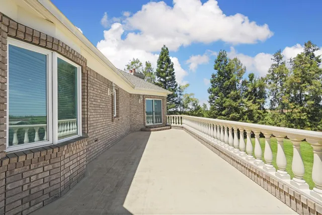 a view of a white house with a big yard and potted plants