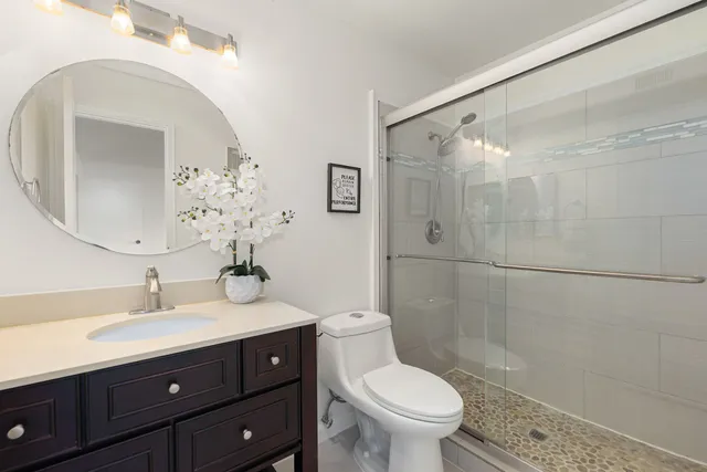 a bathroom with a sink a toilet and shower