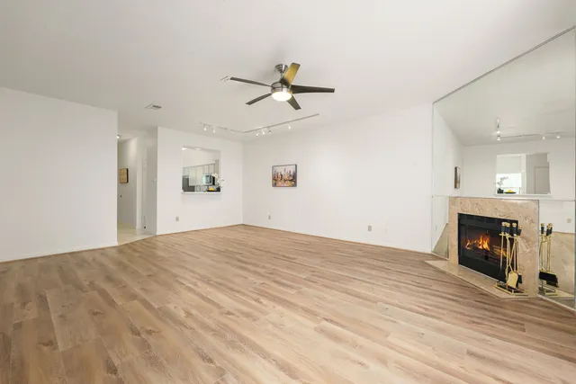 a view of empty room with fireplace and wooden floor