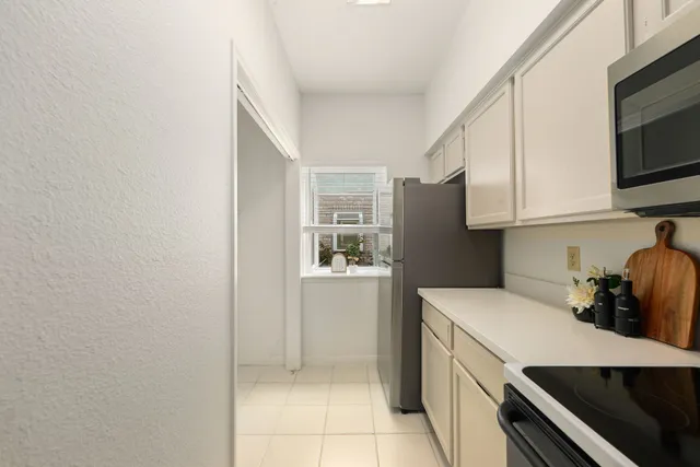 a kitchen with a refrigerator and a stove top oven