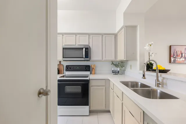 a kitchen with a sink and a stove top oven with wooden floor