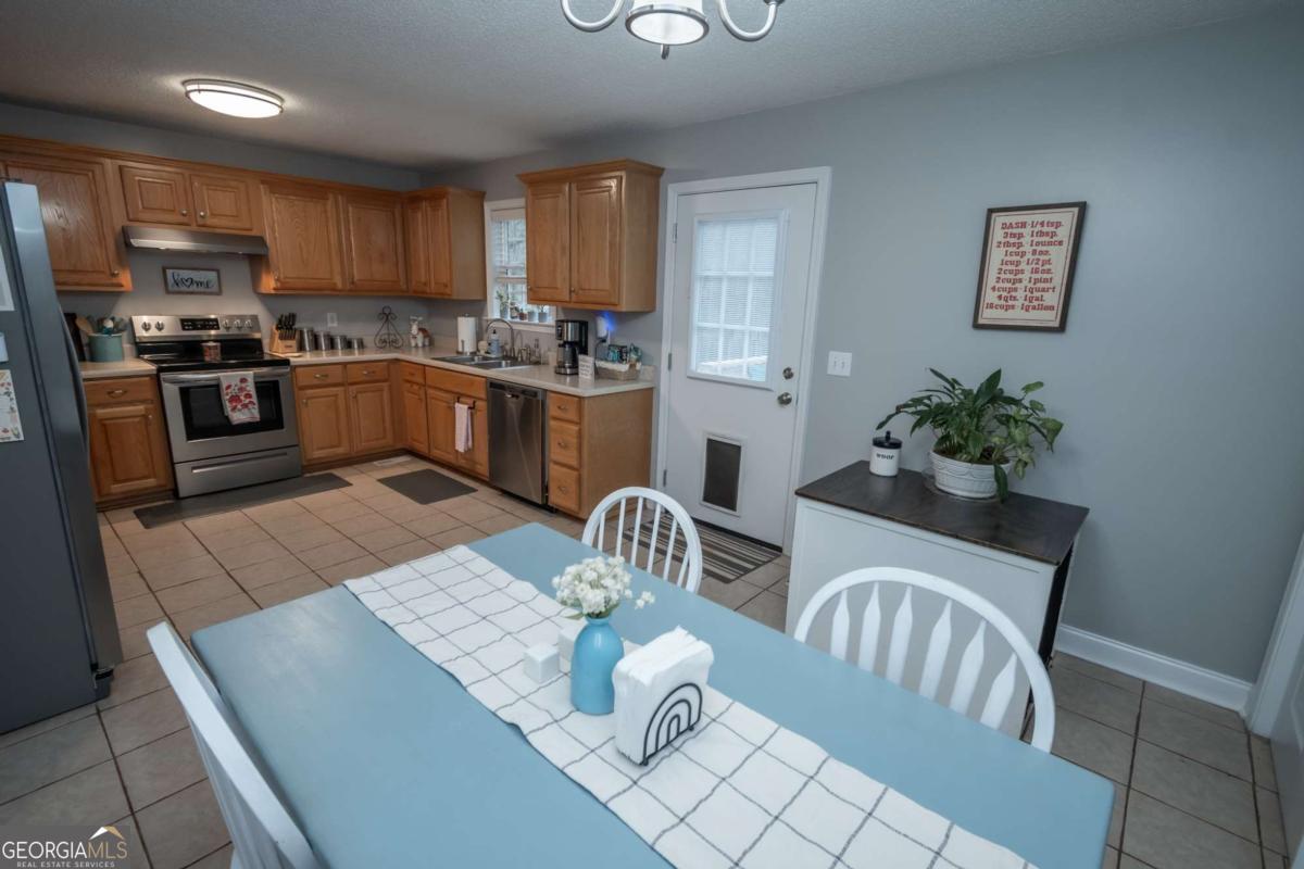 199 Brickyard Road Comer, GA 30629 - Photo 11 of 43 a kitchen with granite countertop stainless steel appliances a sink a stove a table and chairs