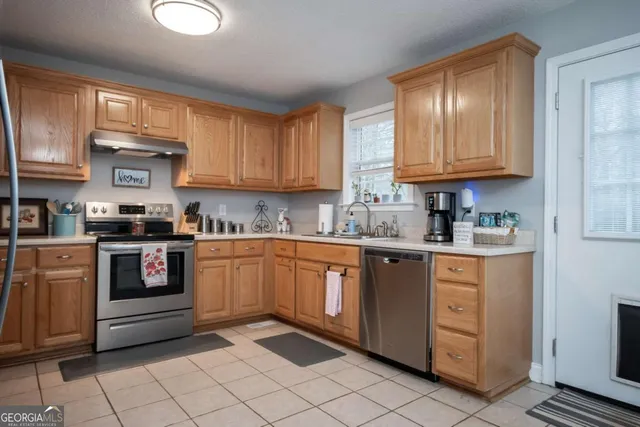 a kitchen with granite countertop cabinets stainless steel appliances a sink and a window