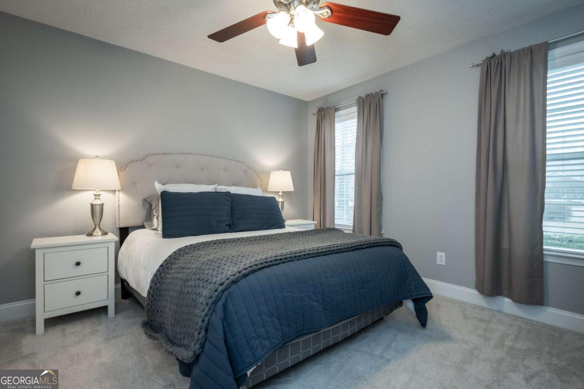 199 Brickyard Road Comer, GA 30629 - Photo 20 of 43 a bedroom with a large bed and a chandelier