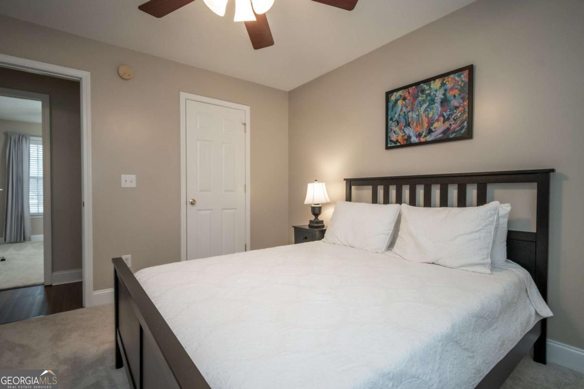 199 Brickyard Road Comer, GA 30629 - Photo 30 of 43 a bedroom with a large bed and a chandelier