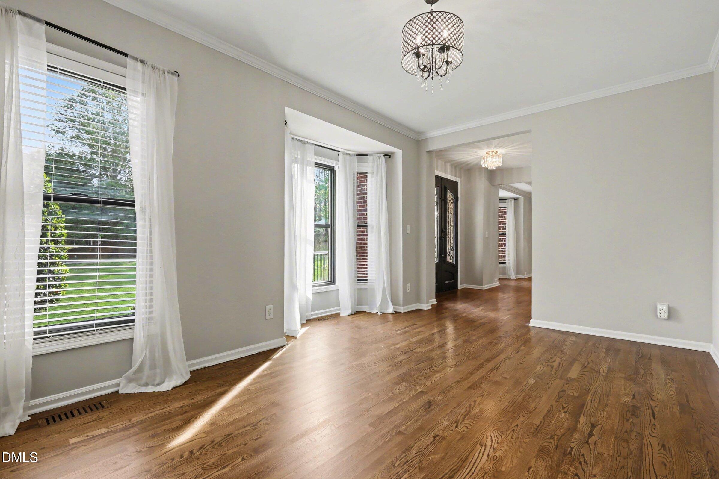 1001 Denfield Court Raleigh, NC 27615 - Photo 11 of 44 an empty room with wooden floor and windows