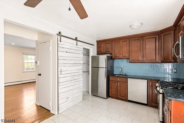 a kitchen with stainless steel appliances granite countertop a refrigerator and a stove top oven