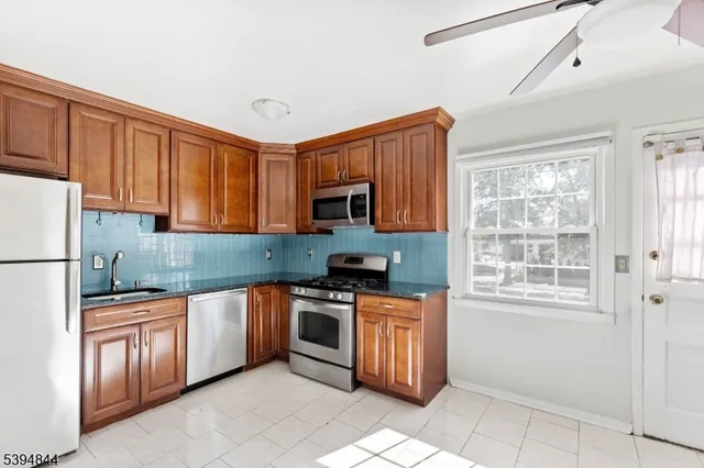 a kitchen with stainless steel appliances granite countertop a stove sink and cabinets