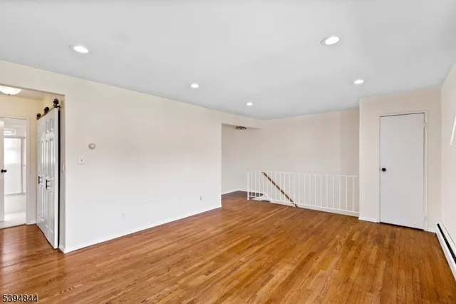 a big room with wooden floor and natural light