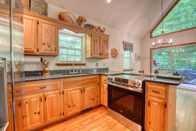 3333 Ellington Road Hayesville, NC 28904 - Photo 35 of 56 a kitchen with granite countertop a stove sink and cabinets