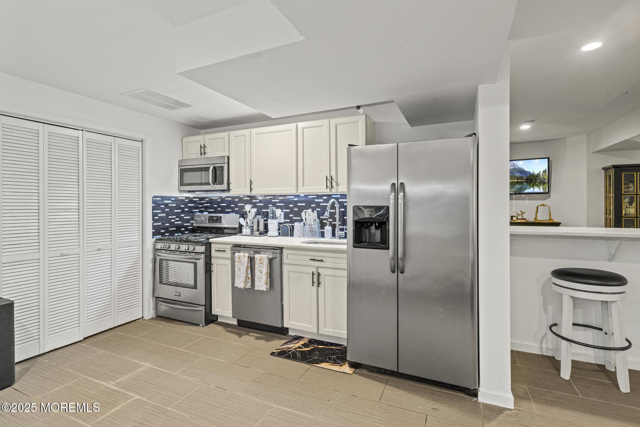 33 Harbor Road Morganville, NJ 07751 - Photo 43 of 49 a kitchen with white cabinets and stainless steel appliances