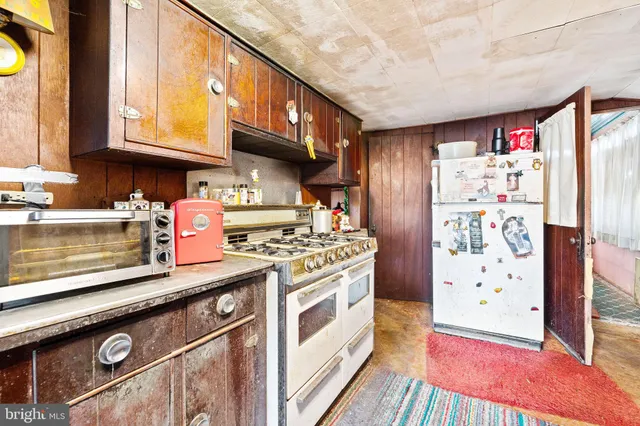 a kitchen with stainless steel appliances granite countertop a refrigerator and a stove