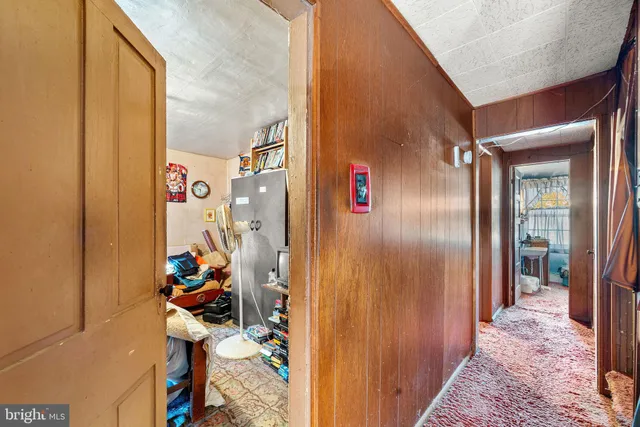 a view of a hallway to a livingroom with furniture and windows
