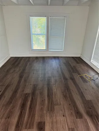 a view of a room with wooden floor and a window