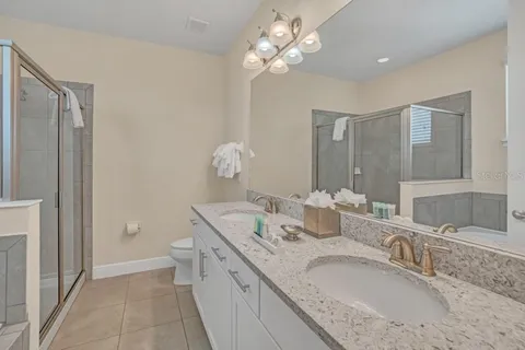 a bathroom with a granite countertop double vanity sink and a mirror
