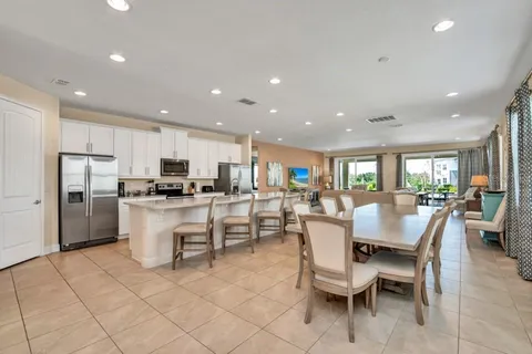 a view of kitchen with refrigerator dining table and chairs