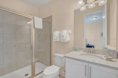 a bathroom with a granite countertop sink a toilet and shower