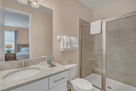 a bathroom with a granite countertop sink toilet and shower