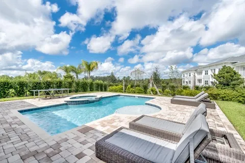 a view of a house with swimming pool and sitting area