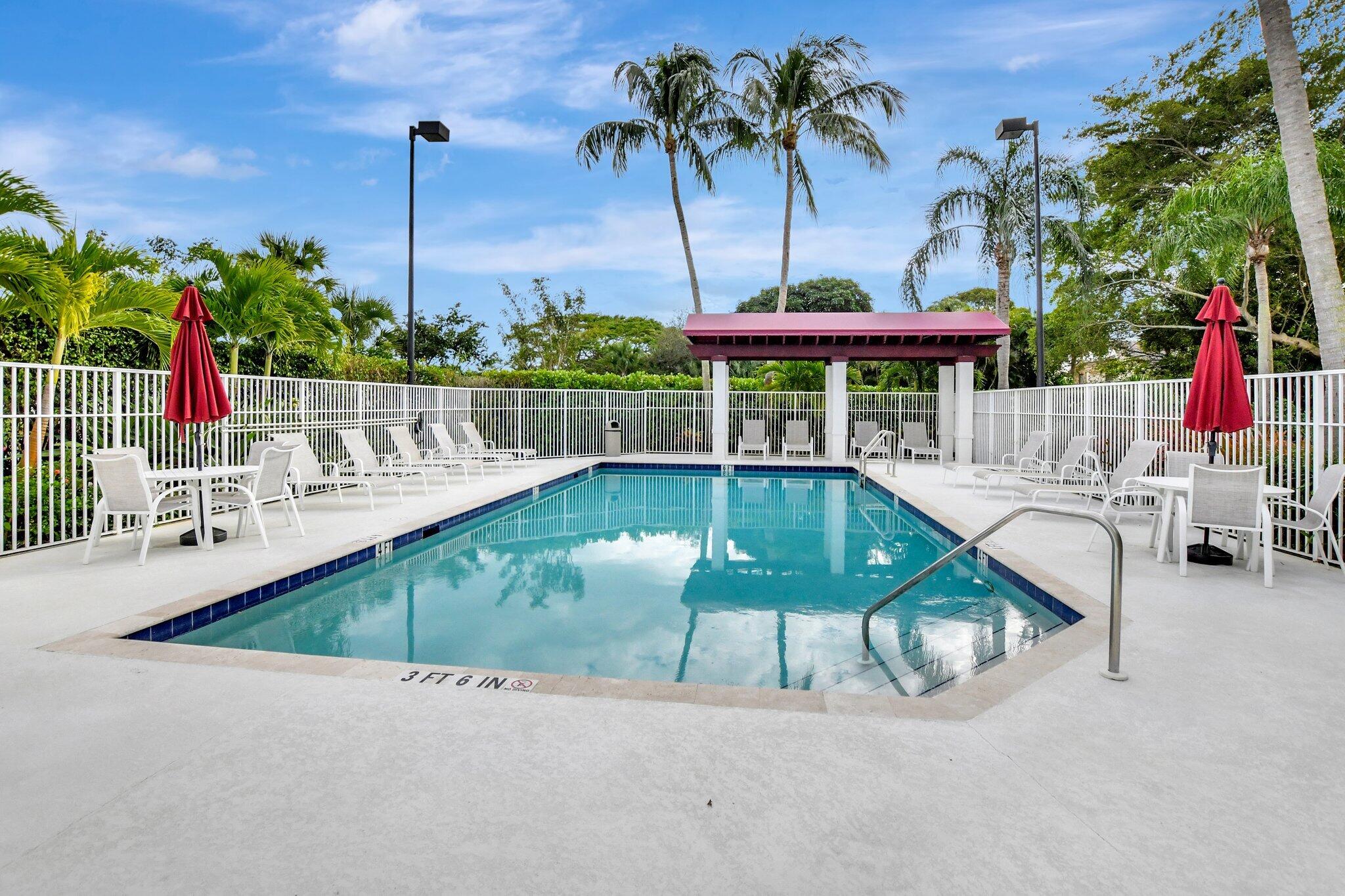 22703 Camino Del Mar, Unit 63 Boca Raton, FL 33433 - Photo 35 of 40 a view of a swimming pool with a patio and a garden