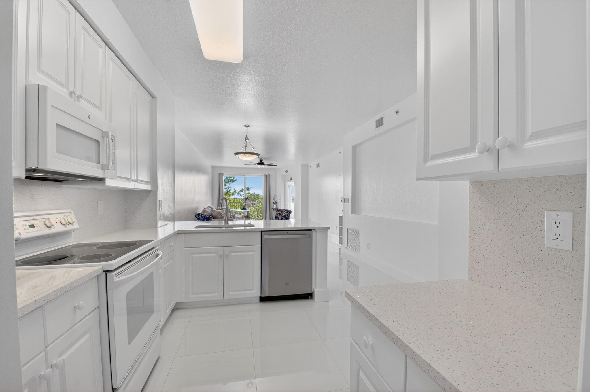 22703 Camino Del Mar, Unit 63 Boca Raton, FL 33433 - Photo 7 of 40 a kitchen with cabinets and white appliances