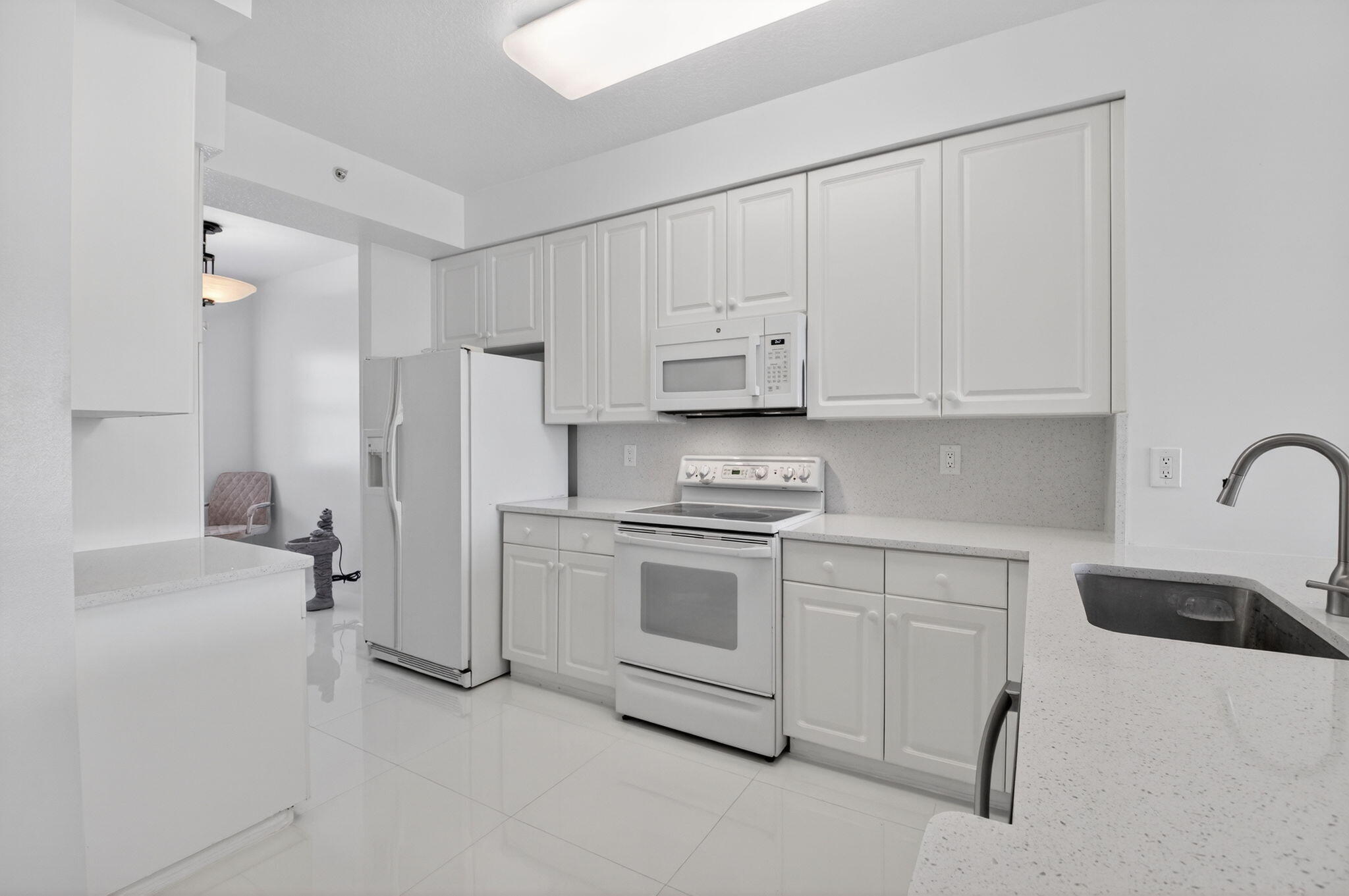 22703 Camino Del Mar, Unit 63 Boca Raton, FL 33433 - Photo 9 of 40 a kitchen with stainless steel appliances white cabinets and a sink