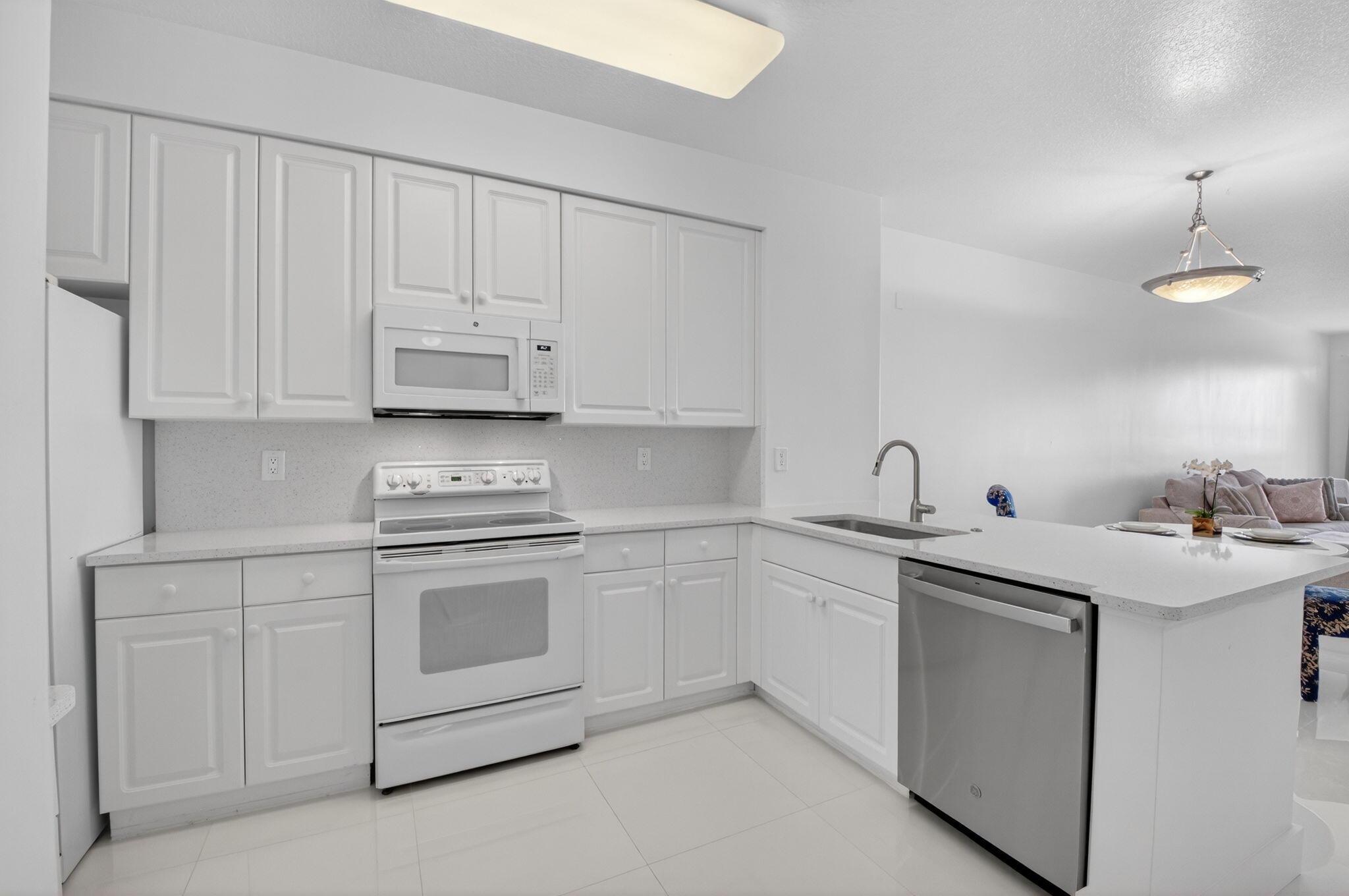 22703 Camino Del Mar, Unit 63 Boca Raton, FL 33433 - Photo 10 of 40 a kitchen with white cabinets and white appliances